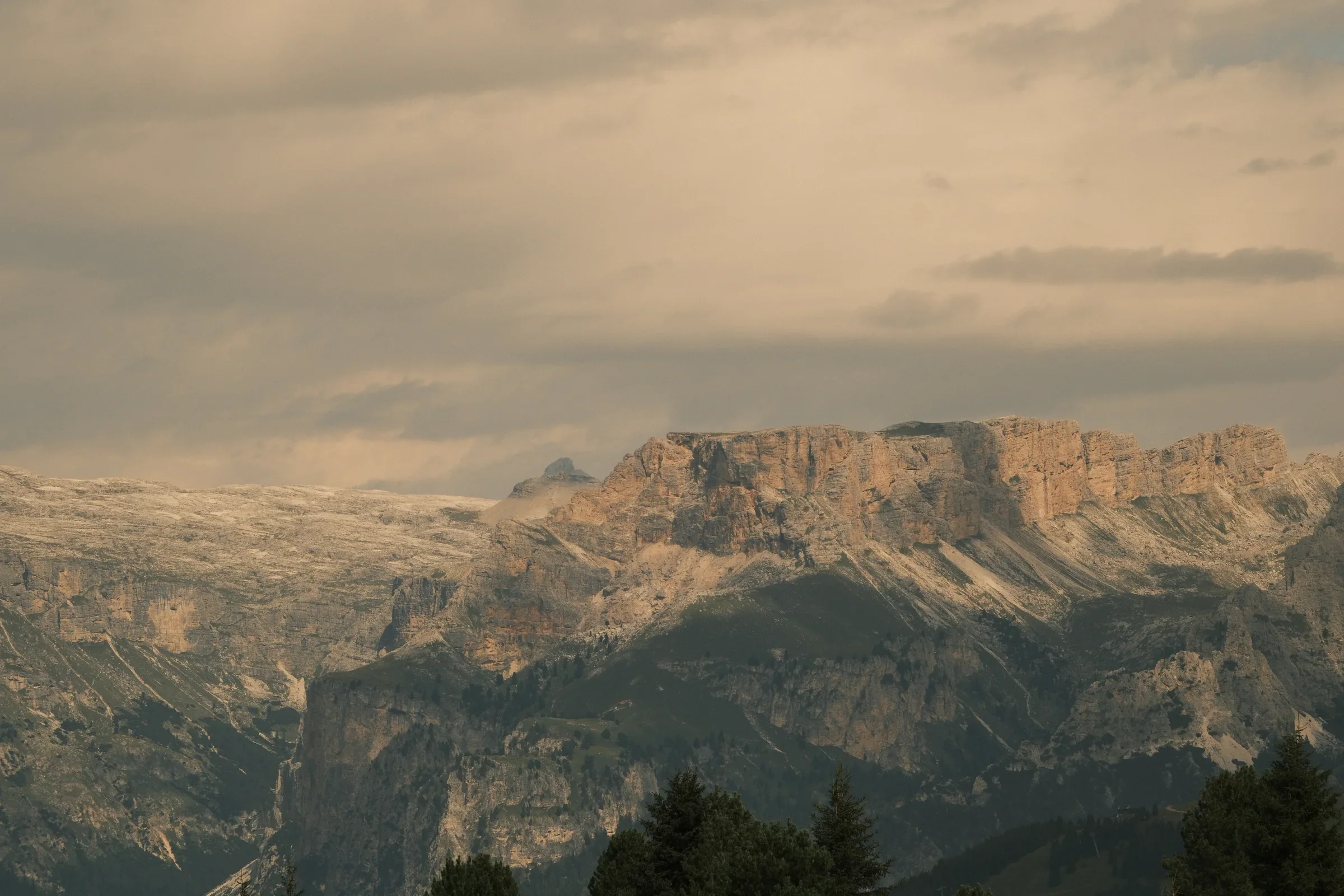 A wide mountain range held in soft golden evening light