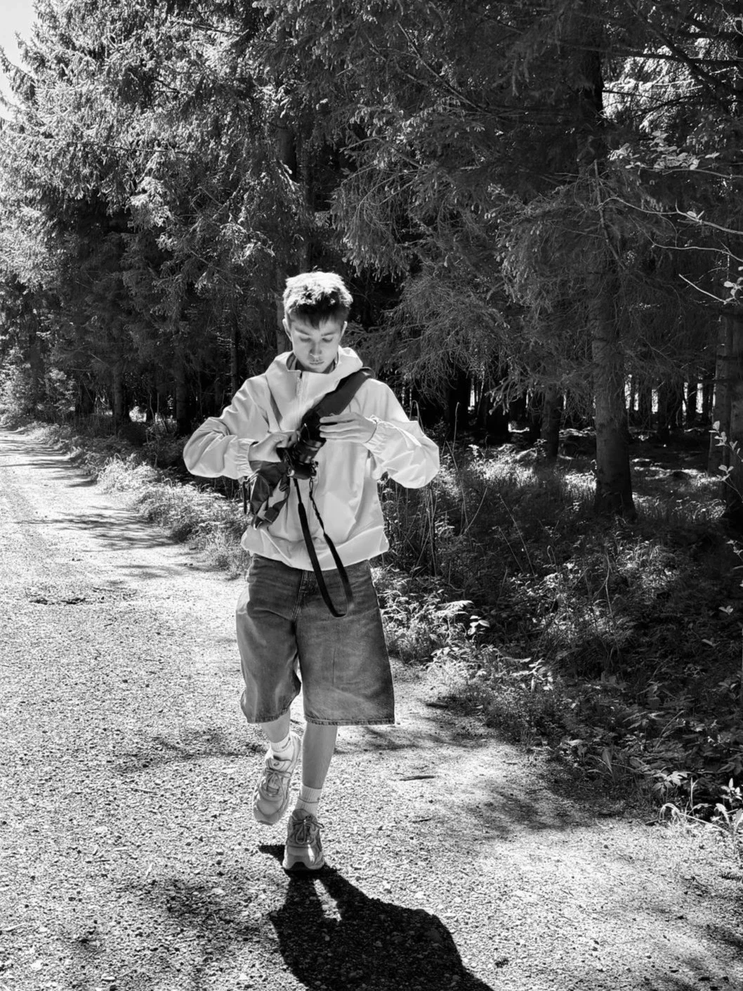 Frederik Strobl walking along a forest path with his camera